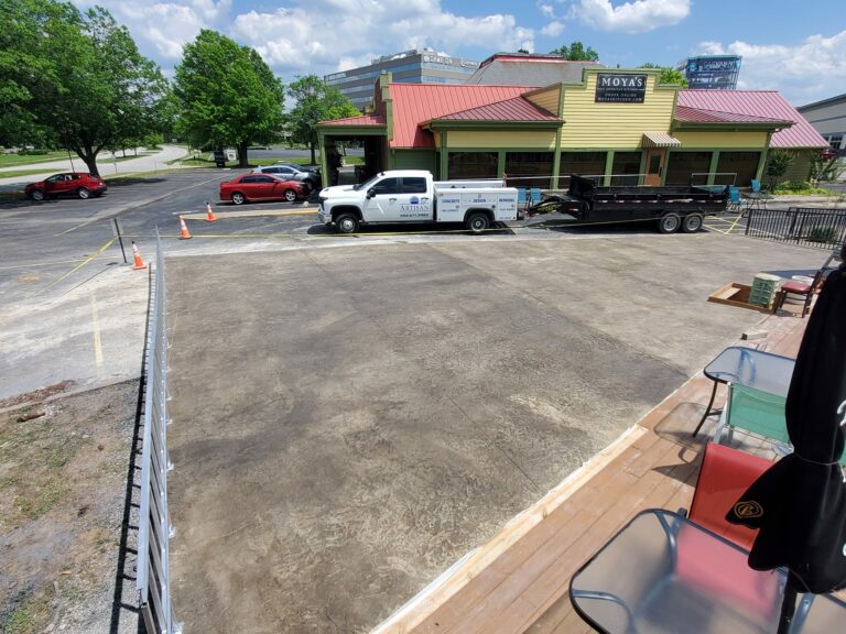 Artisan Construction truck parked in front of a freshly cured concrete patio