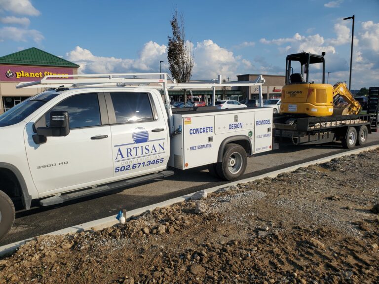 Artisan Construction truck onsite with large equipment behind it