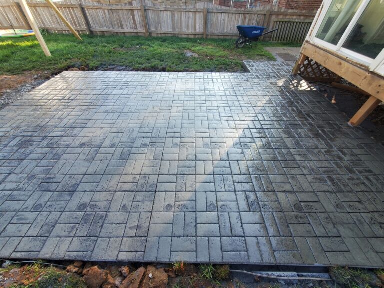 Residential concrete patio that's been stamped in an Ashlar pattern and dyed grey & brown